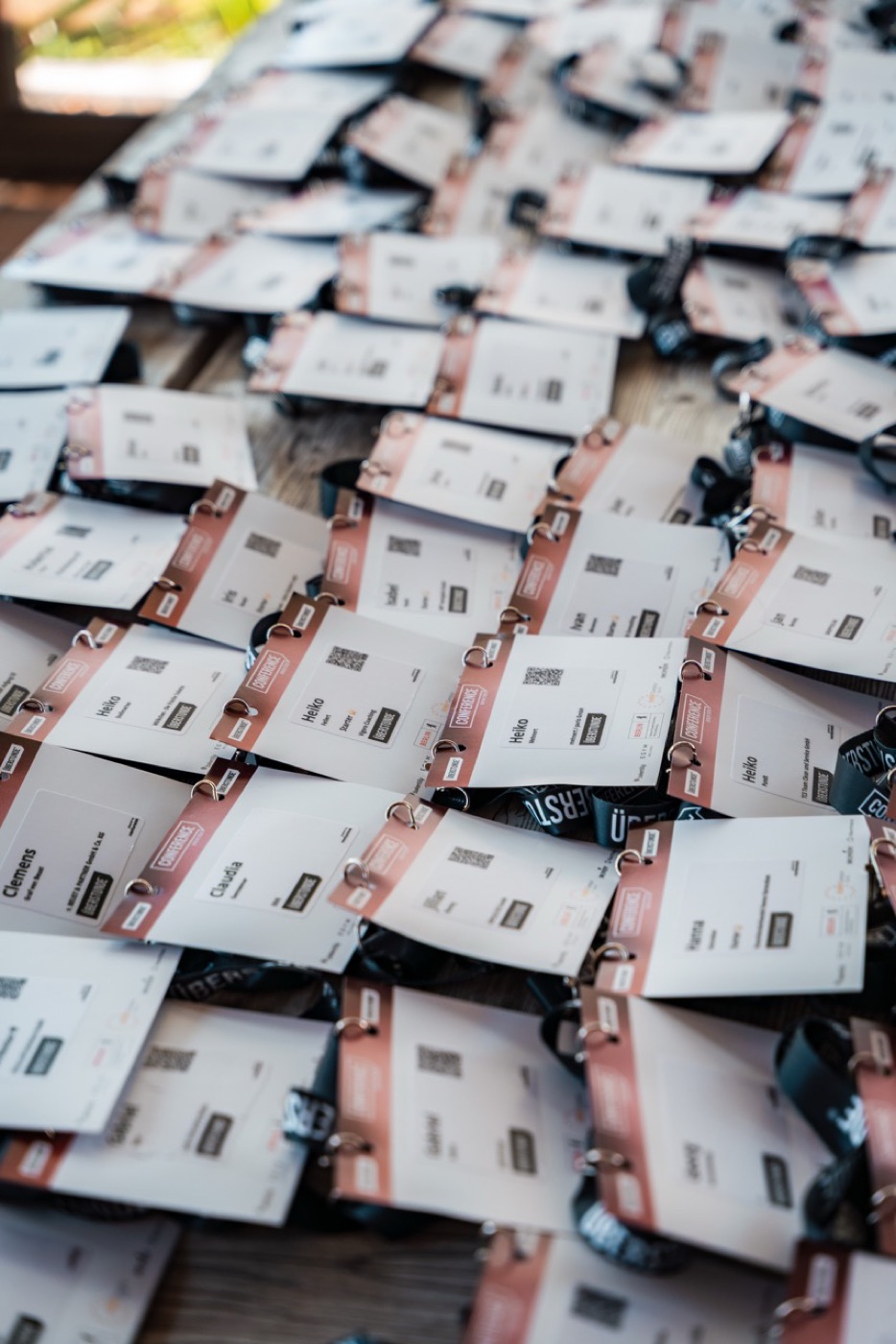 Stapel gedruckter Namensschilder mit Lanyard und QR-Code, bereit zur Ausgabe